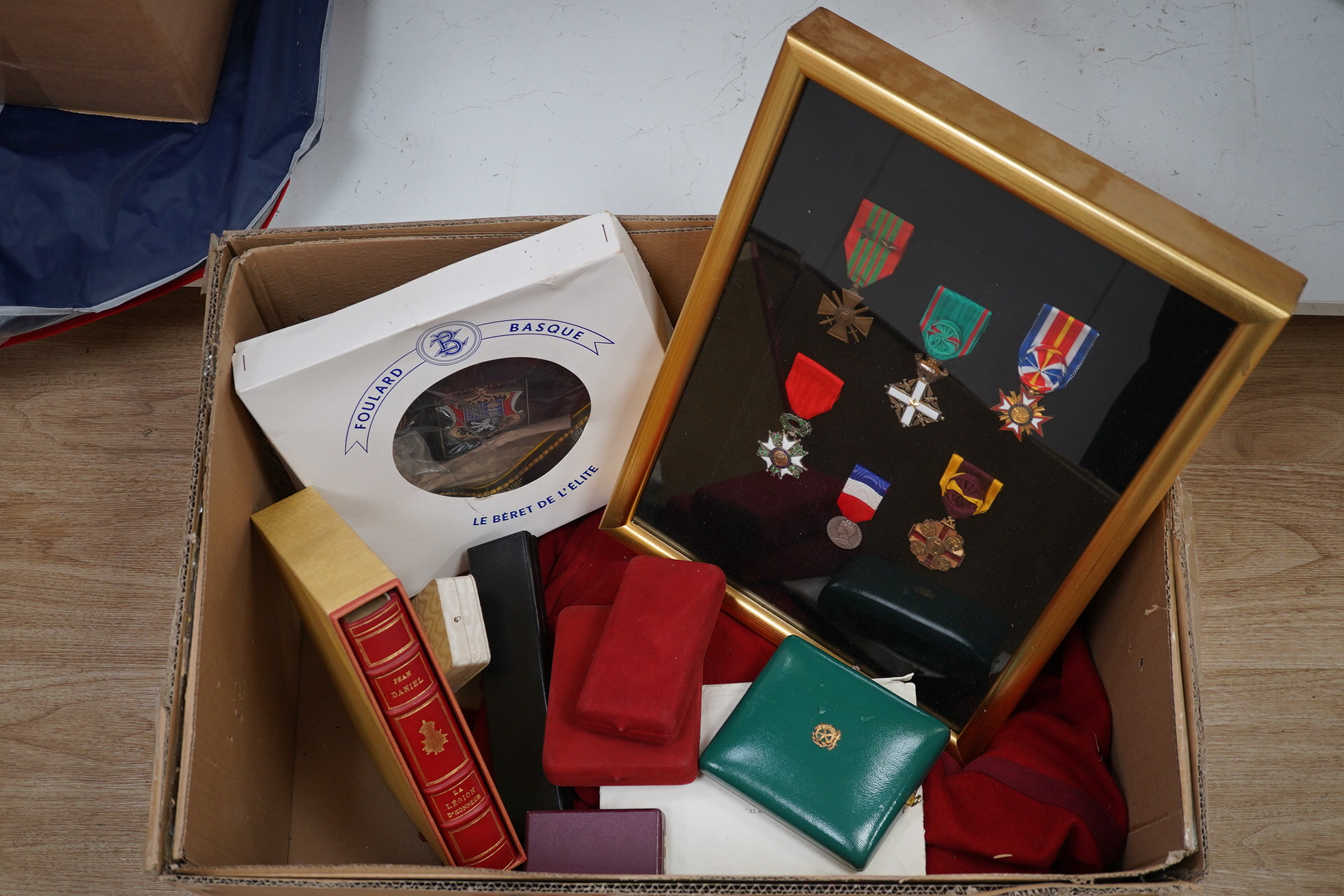 A framed medal group; Legion D'Honneur France, a British Cross, Italian order of Merit and Croix De Guerre with related book; La Legion d’Honneur by Jean Daniel, plus some related paperwork, three related medal miniature